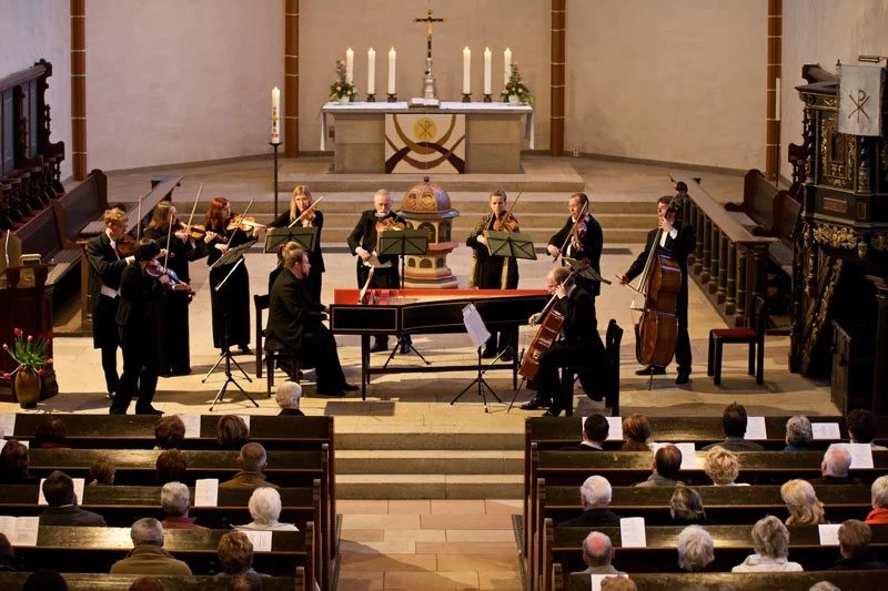 Das Kammerorchester spielt in einer Kirche vor Publikum.