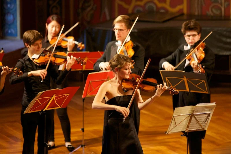 Streicher an roten Notenpulten im Konzert auf der Wartburg.
