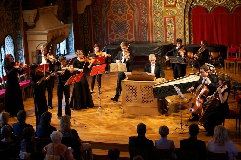 Das Orchester mit Cembalo vor Publikum im Festsaal.
