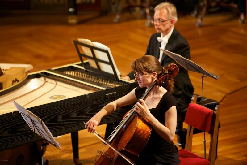 Eine Cellistin, dahinter Cembalo und Kontrabass.
