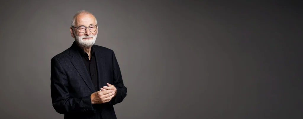 Wolfgang Fuchs, Gründer der Stiftung, vor grauem Hintergrund.